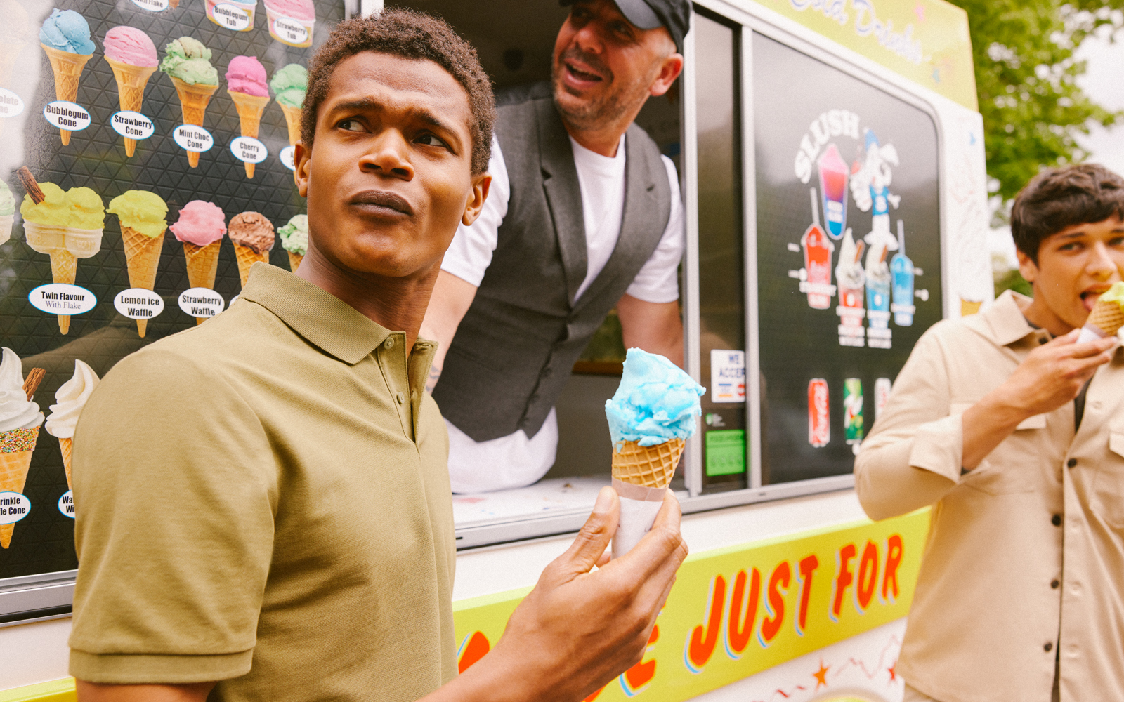 Men standing at an ice cream van in the summer wearing Mss Bros merino polo shirts.