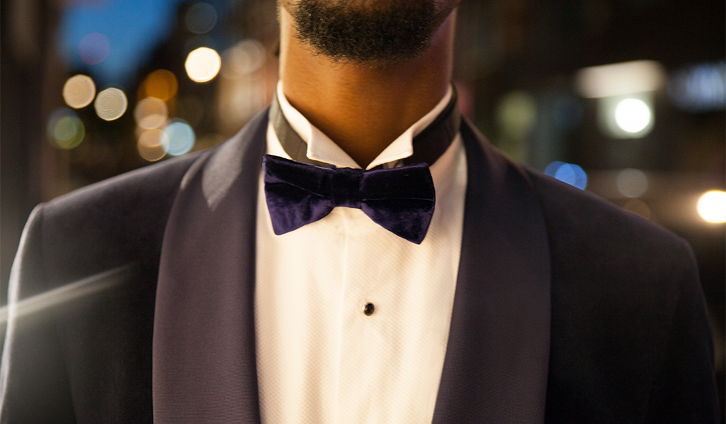 Man in perfectly fitting pre-tied bow tie and tuxedo.