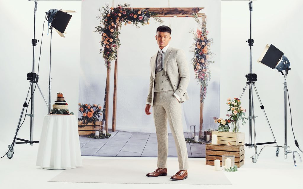What to wear to get married abroad ; a groom wears a white wedding suit for a summer wedding