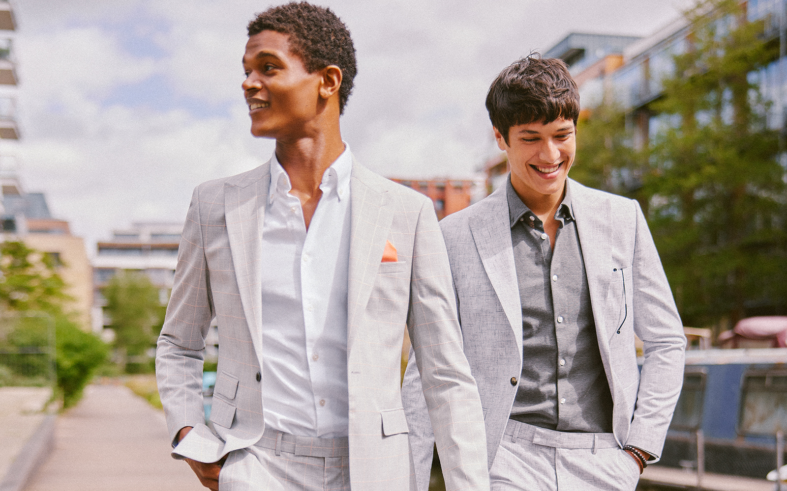 Smiling men walking in grey summer wedding suits 