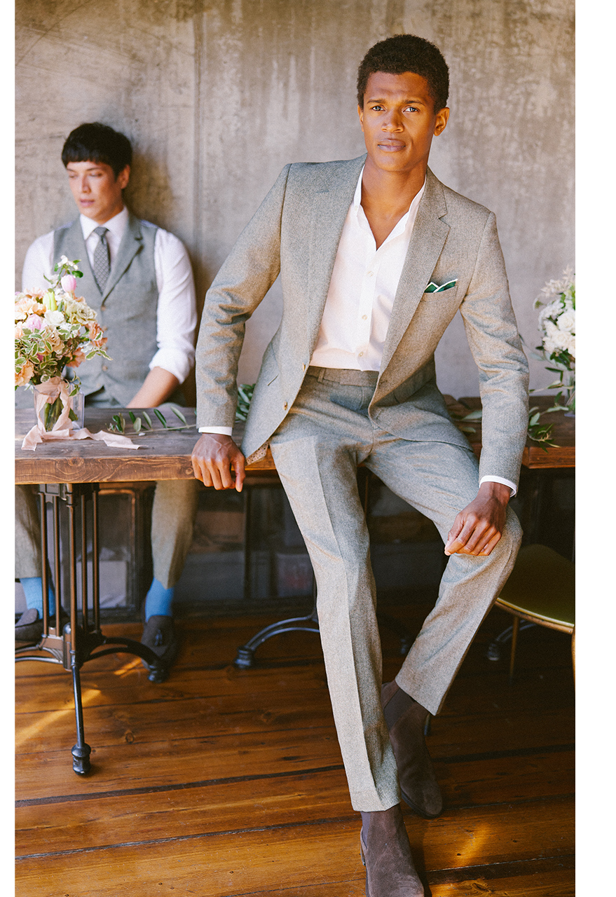 Wedding guests sat wearing light summer suits and open necked white cotton shirts.