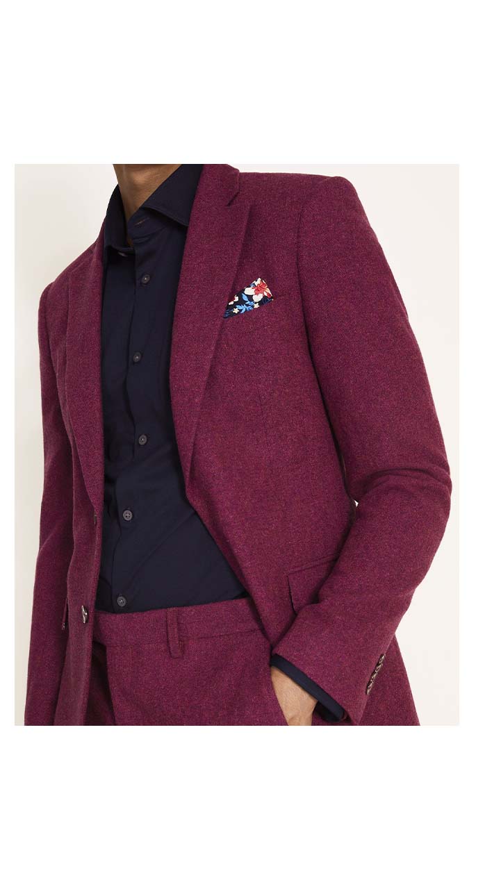 Man in maroon tweed suit with navy shirt and floral pocket square