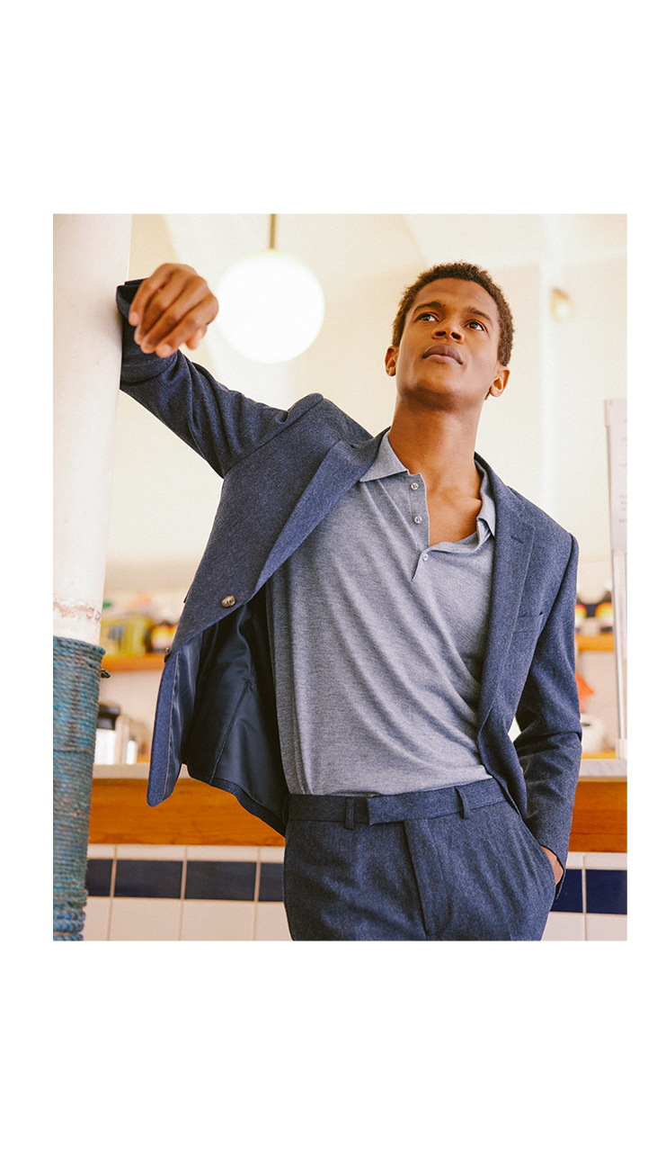 Man in stylish work blue polo shirt and dark blue suit.