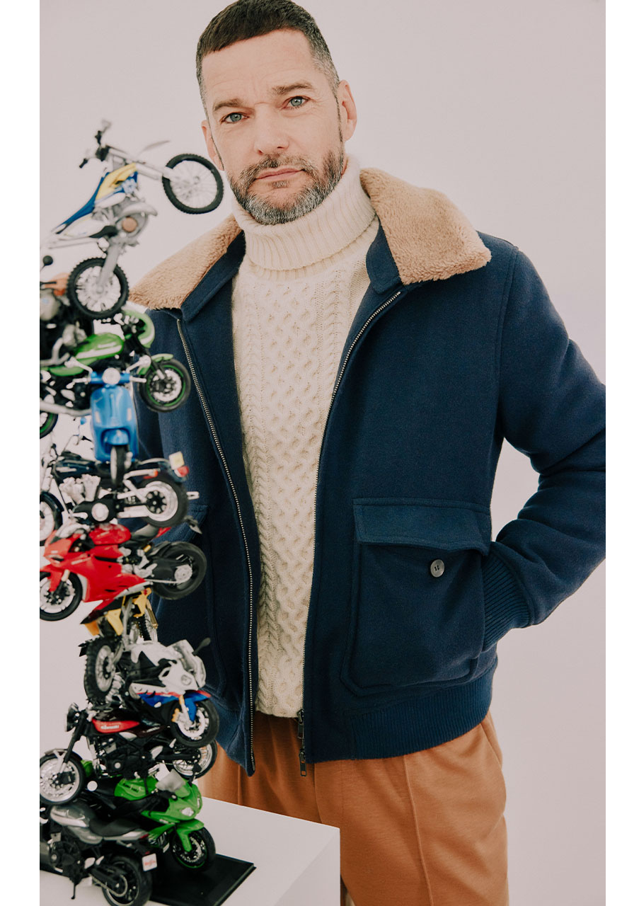 Fred Sirieix in white thick knit roll neck jumper, Moss Bros chestnut trousers and navy jacket with fur lining
