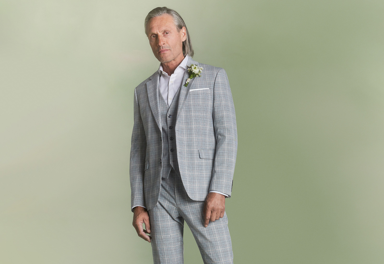 Groom in three-piece statement suit, checkered with a white shirt.